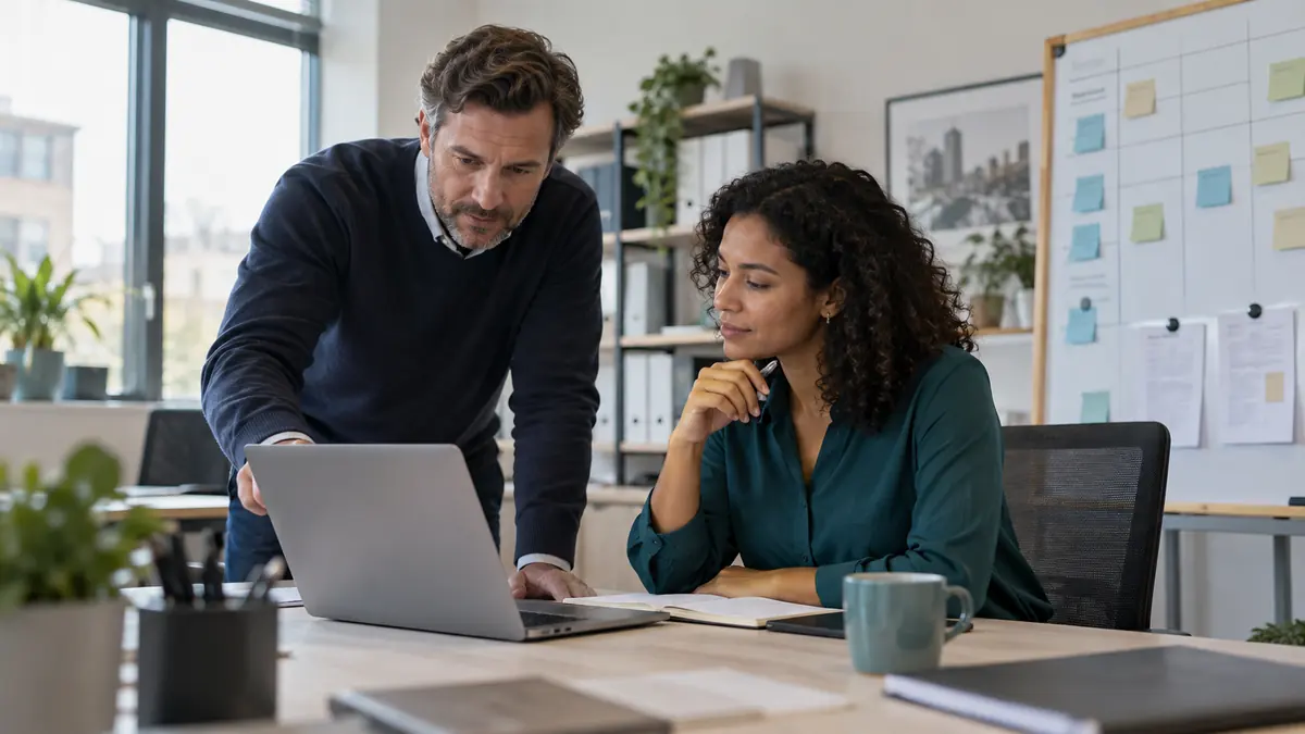 Two staffing coordinators reviewing an assignment extension plan in a bright office